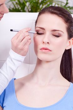 at the cosmetic studio eyeliner on eyes doing make up woman portrait closeup