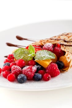 fresh tasty homemade crepe pancake with chocolate sauce fruits and berries