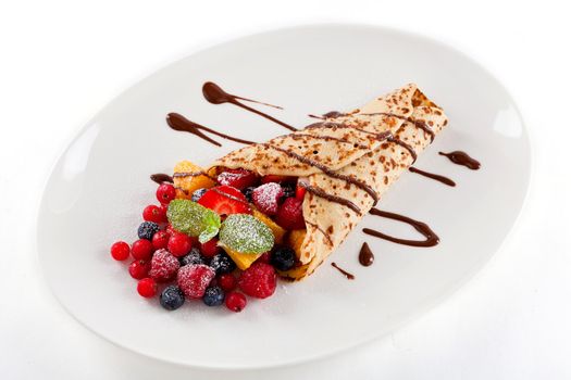 fresh tasty homemade crepe pancake with chocolate sauce fruits and berries