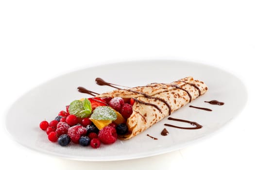 fresh tasty homemade crepe pancake with chocolate sauce fruits and berries