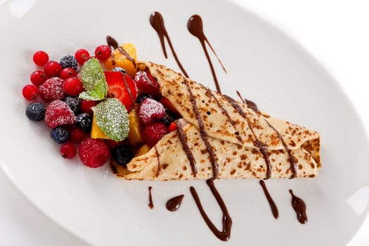 fresh tasty homemade crepe pancake with chocolate sauce fruits and berries