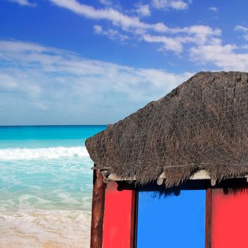 hut red palapa at turquoise beach of caribbean sea in a sunny blue sky day