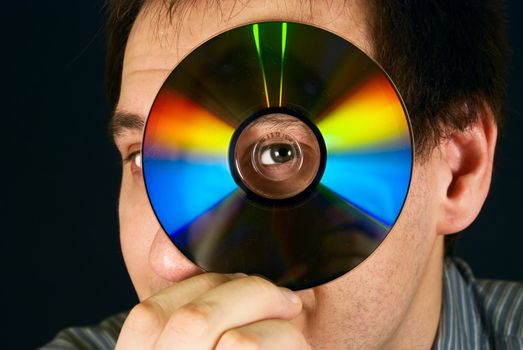 portrait of a man looking through a CD