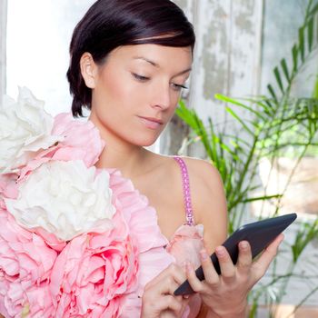fashion woman and tablet ebook reading at home with spring pink flowers dress