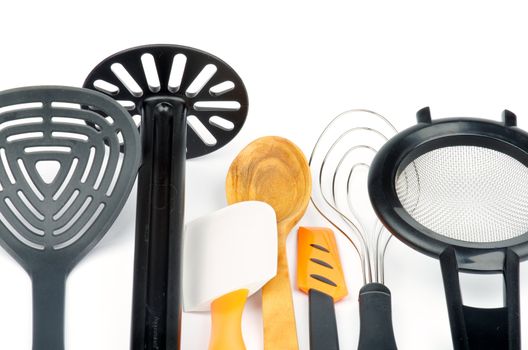 Set of Kitchen Utensils with Slotted Spoon, Potato Musher, Spatula, Wooden Spoon, Cream Spatula, Wire Whisk and Colander isolated on white background