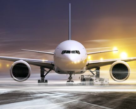 white plane in airport at non-flying weather, blowing snow