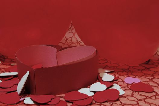 A valentine background of material with hearts and hearts cut-outs and balloons