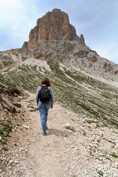 woman plays trekking on Catinaccio mountain, Italian Dolomites