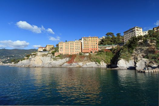 coastline with typical homes surrounding the sea in Camogli, small town in Mediterranean sea, Italy