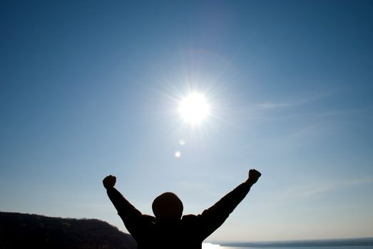 man with his arms apart against the blue sky