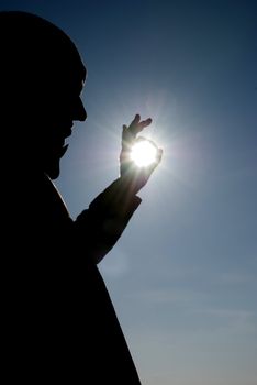 man holding a sun in his hands against the sky