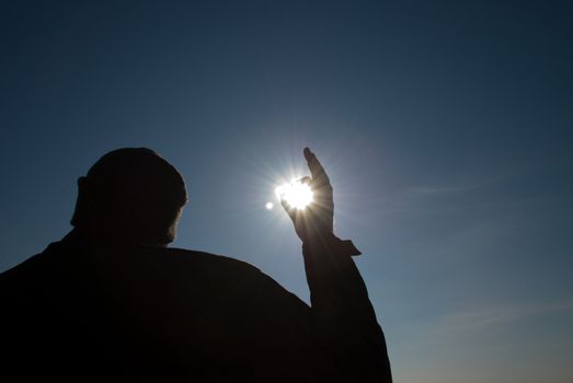 man holding a sun in his hands against the sky