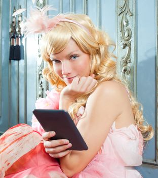 blond fashion princess woman reading ebook tablet with retro spring pink dress