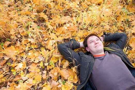 portrait of a man lying on autumn leaves