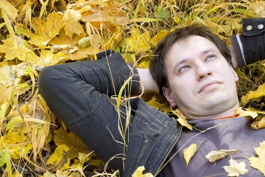 portrait of a man lying on autumn leaves