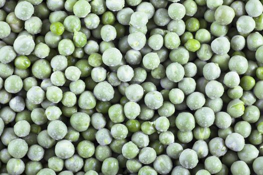 Fresh green peas covered with water drops, food background.