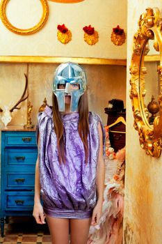 Futuristic fashion woman in retro grunge home with steel helmet