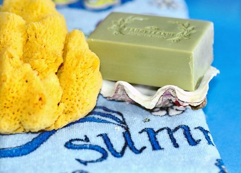Beach towel, natural olive soap on clamshell valve and sea sponge