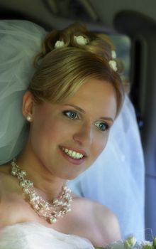 Beautiful the bride with bouquet in car