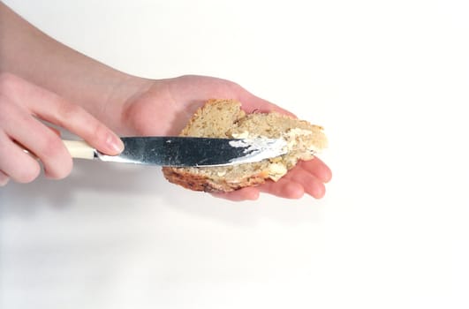 Girl's hands with a slice of bread and a knife