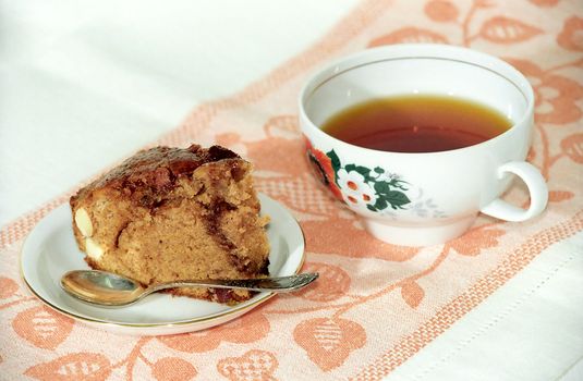 Chocolate cake with nuts and tea on rustic diaper