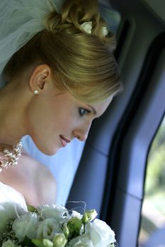 Beautiful the bride with bouquet in car