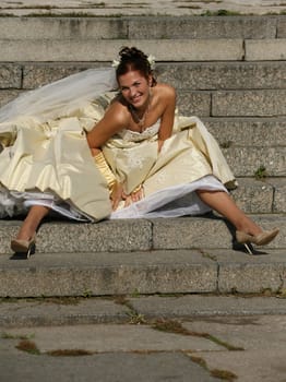 The beautiful bride sitting on a stone ladder