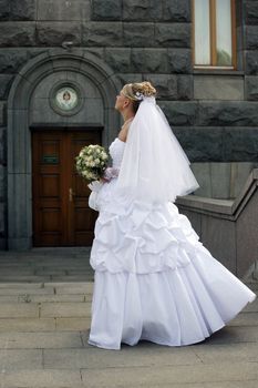 The beautiful bride with a bouquet on a background of church