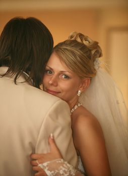 Smiling bride gently embraces the groom