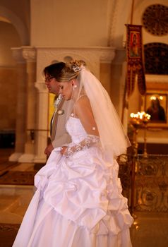 The groom and the bride with candles. Wedding ceremony in church