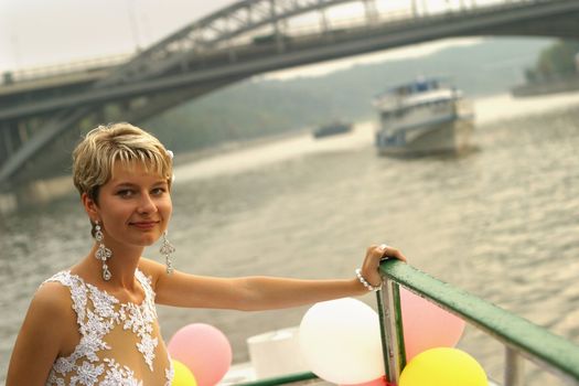 Smiling bride stands by the steam-ship