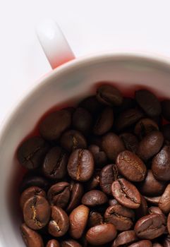 Grains of coffee in a white bowl. Macro-ring