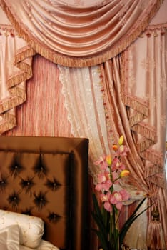 A modern bedroom with pink satin curtain