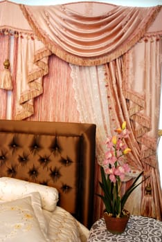 A modern bedroom with pink satin curtain