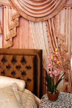 A modern bedroom with pink satin curtain