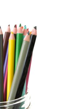 Colorful pencils in a jar against a white background.  Copy space available. Used a shallow depth of field with selective focus.