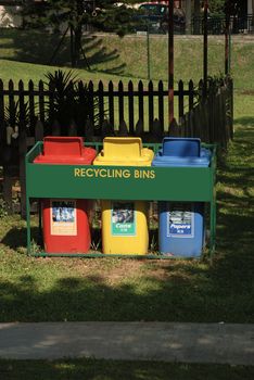 View of three recyling bins in a garden