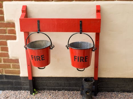 Two red fire buckets hanging on a wall