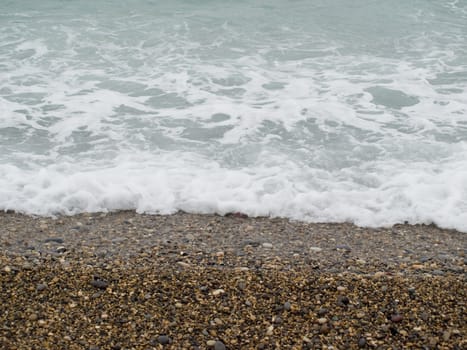 Waves washing over stones on a beach