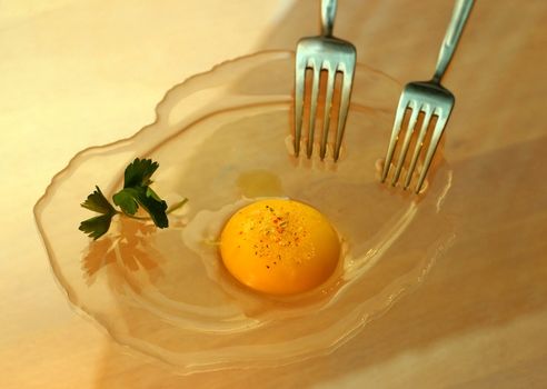 The image of a fork and broken eggs a description