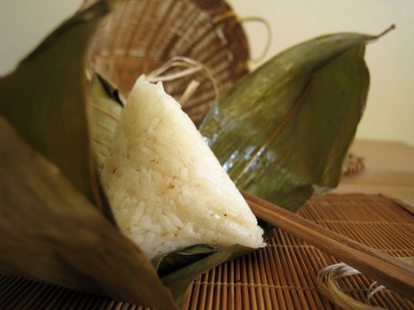 a pyramid-shaped mass of glutinous rice wrapped in leaves, special food for the Dragon Boat Festival (falling on the fifth day of the fifth lunar month), one culture occasion in Chinese