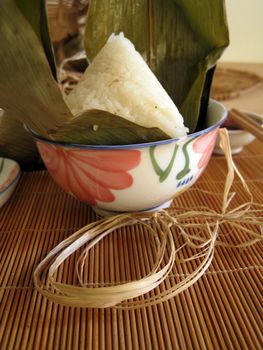 a pyramid-shaped mass of glutinous rice wrapped in leaves, special food for the Dragon Boat Festival (falling on the fifth day of the fifth lunar month), one culture occasion in Chinese