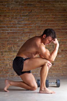 muscle shaped man on knee thinking with thinker posture