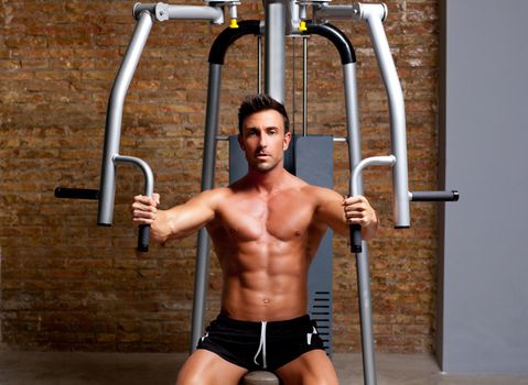 muscle shaped man exercise on sport gym fitness club in brick wall