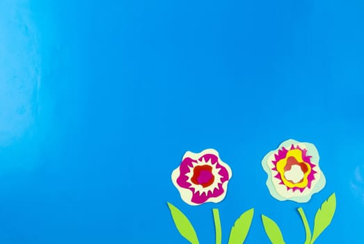 colored paper flowers on blue background