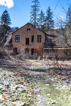 abandoned, ruined house in daylight against blue sky