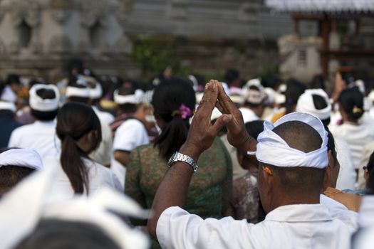 Balinese people praying at temple ceremony