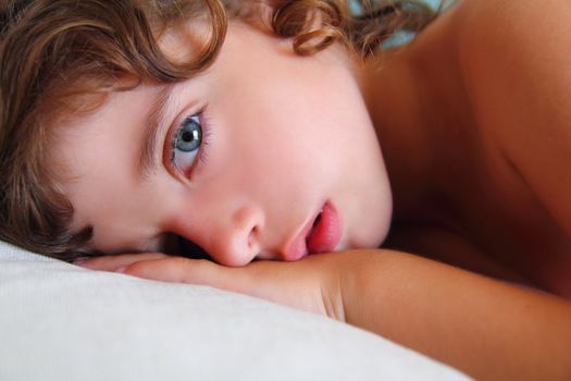 child girl relaxed on pillow looking camera with blue eyes