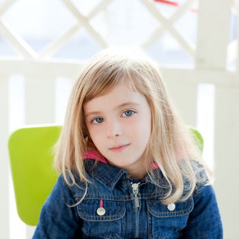 blue eyes kid girl portrait outdoor sit in green chair