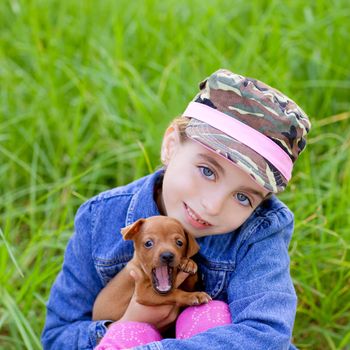 little girl with pet puppy mascot mini pinscher in outdoor green grass